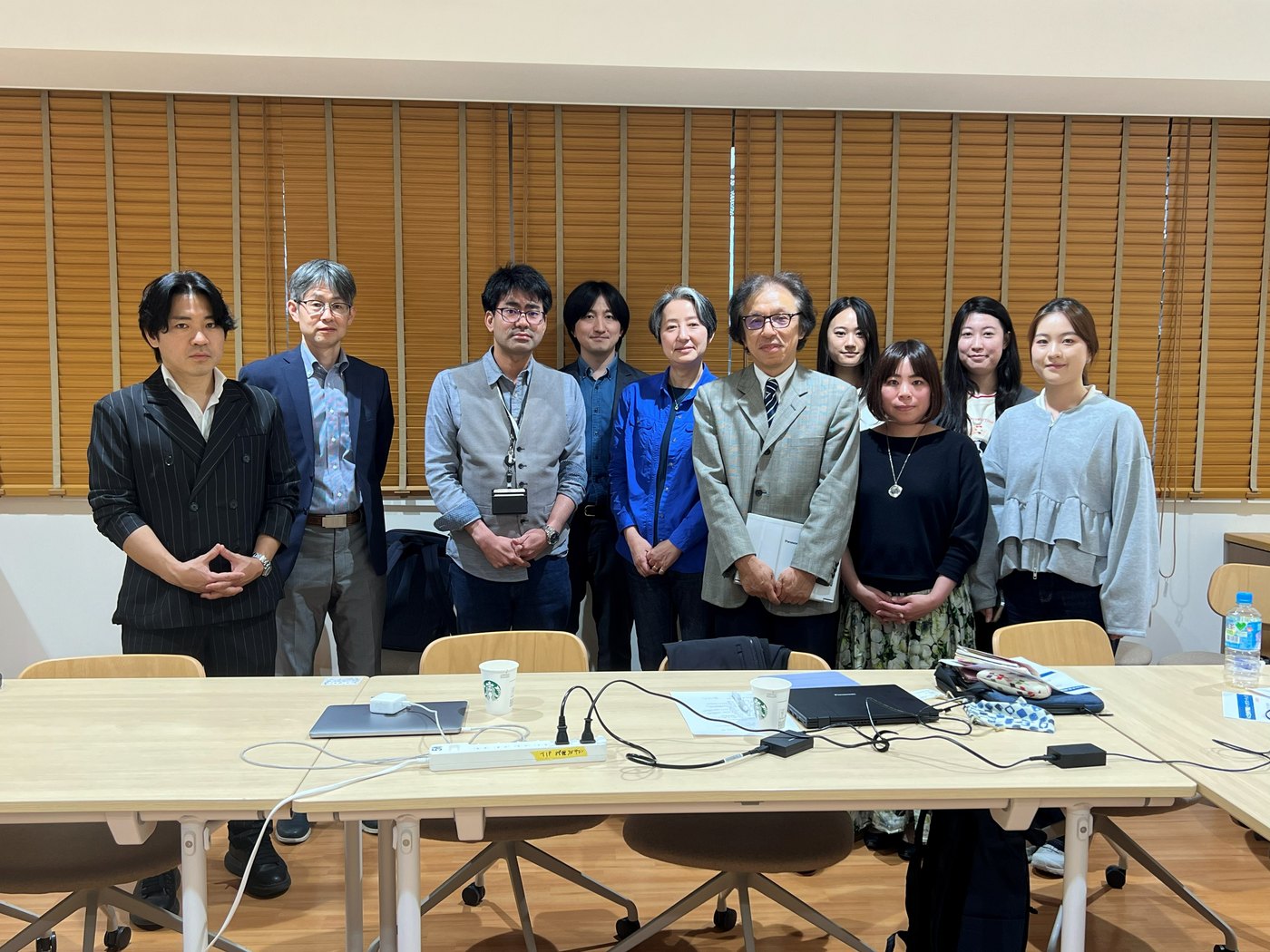 キックオフミーティングの集合写真。会議室で参加者が並んでいる様子